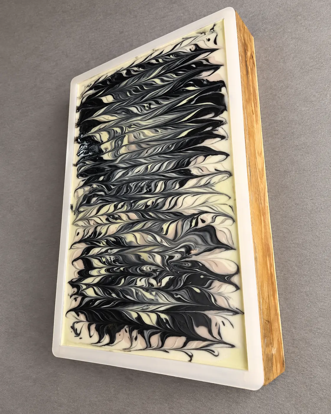 Black and cream handcrafted botanical soap with a flowing swirl pattern