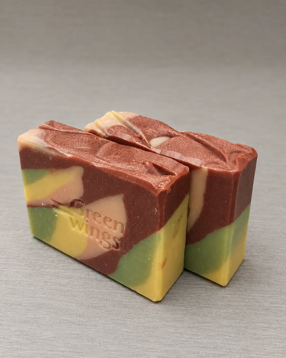 Two colourful handcrafted Greenwings soap bars with botanical marbling