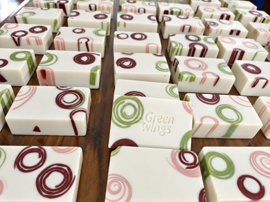 Close-up of handcrafted patterned Greenwings soap bars curing in the studio